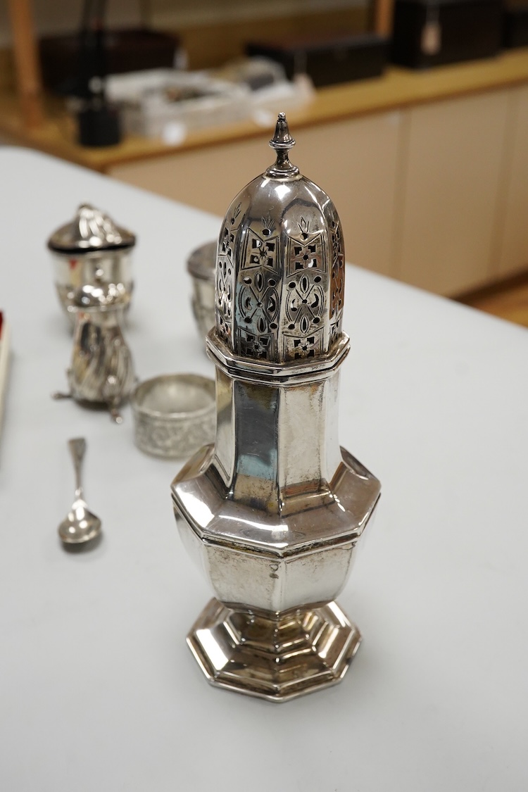 A George V silver octagonal sugar caster, Viners Ltd, Sheffield, 1932, 18.2cm, an Edwardian silver three piece condiment set by John Round, a silver napkin ring and three silver spoons including a dessert spoon by Peter,